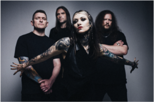 Tattooed musician with braided hair posing with band