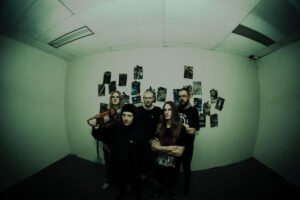 Band posing in dim green room